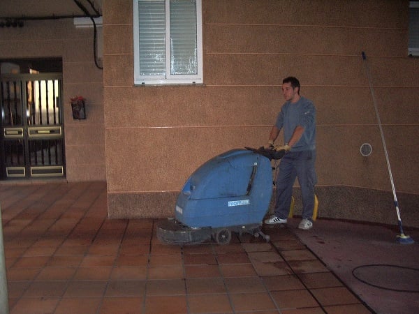 Operario de Galiport limpiando un soportal con fregadora industrial en A Coruña